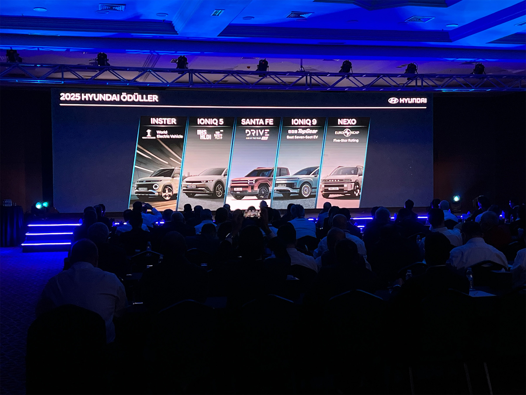 Wide LED screen showing award categories at the Hyundai dealer meeting, with the audience in the hall